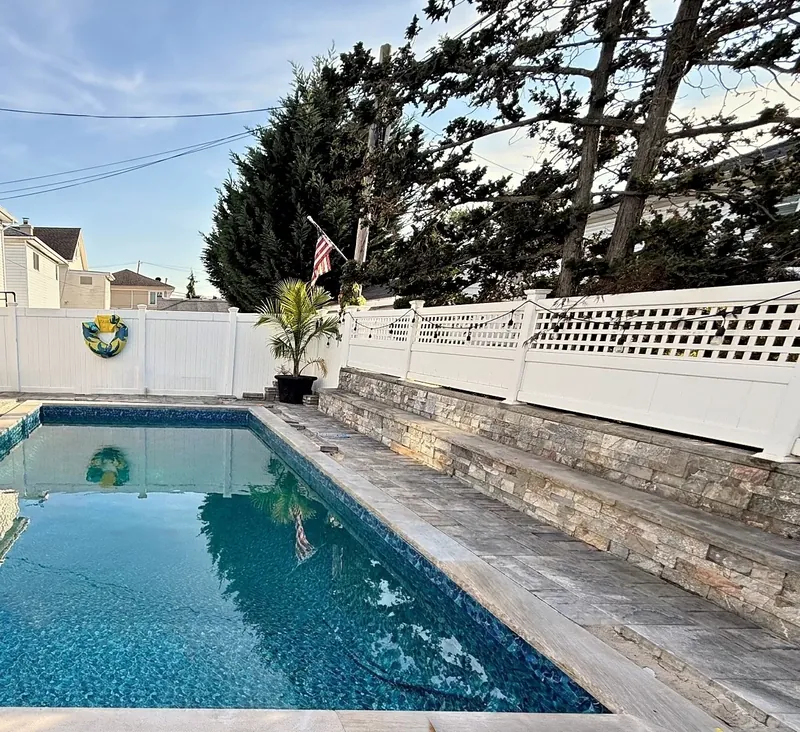 Finished pool filled, with stone coping and paver patio