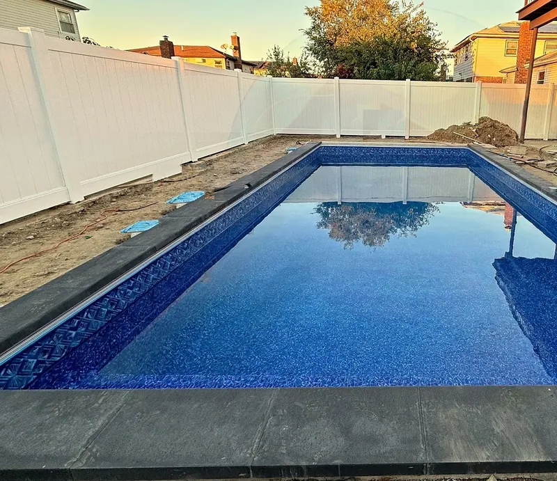 Finished pool with new liner, dark coping and the auto-cover track