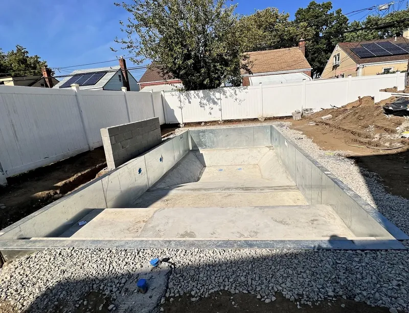 Pool floor finished, stone backfill placed and the block wall for the waterfall started