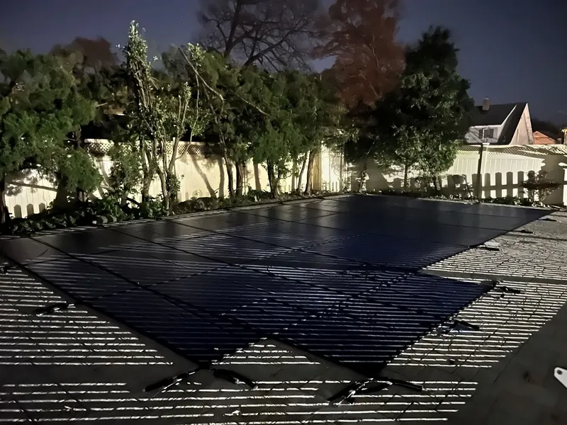 Winter safety cover installed, with the pool-barrier fence behind